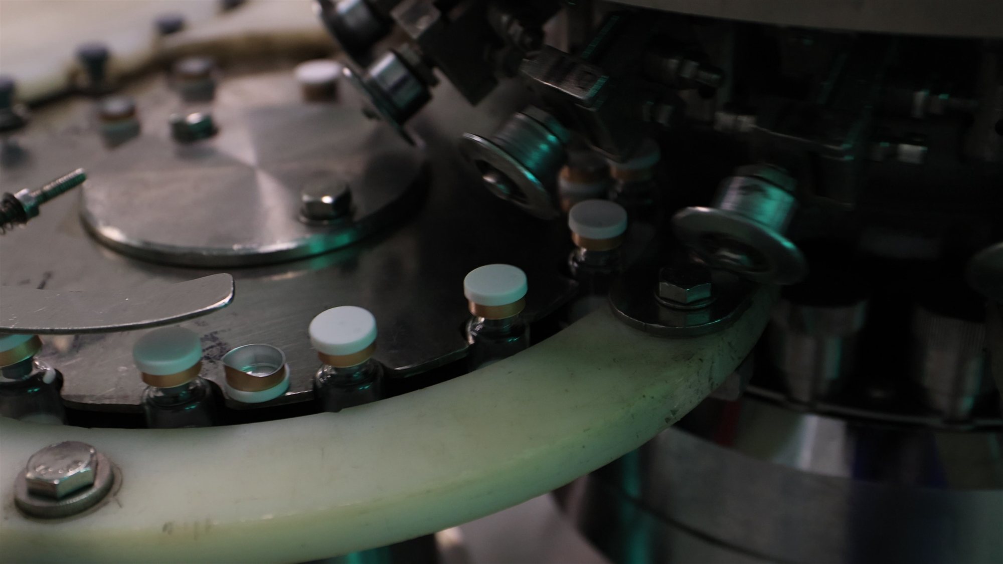 Vials moving through a rotary filling machine at the jogonglabs factory