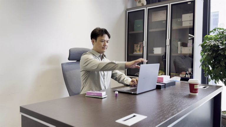 Tyler, founder of jogonglabs, reviewing documents at his desk in the Guangzhou office