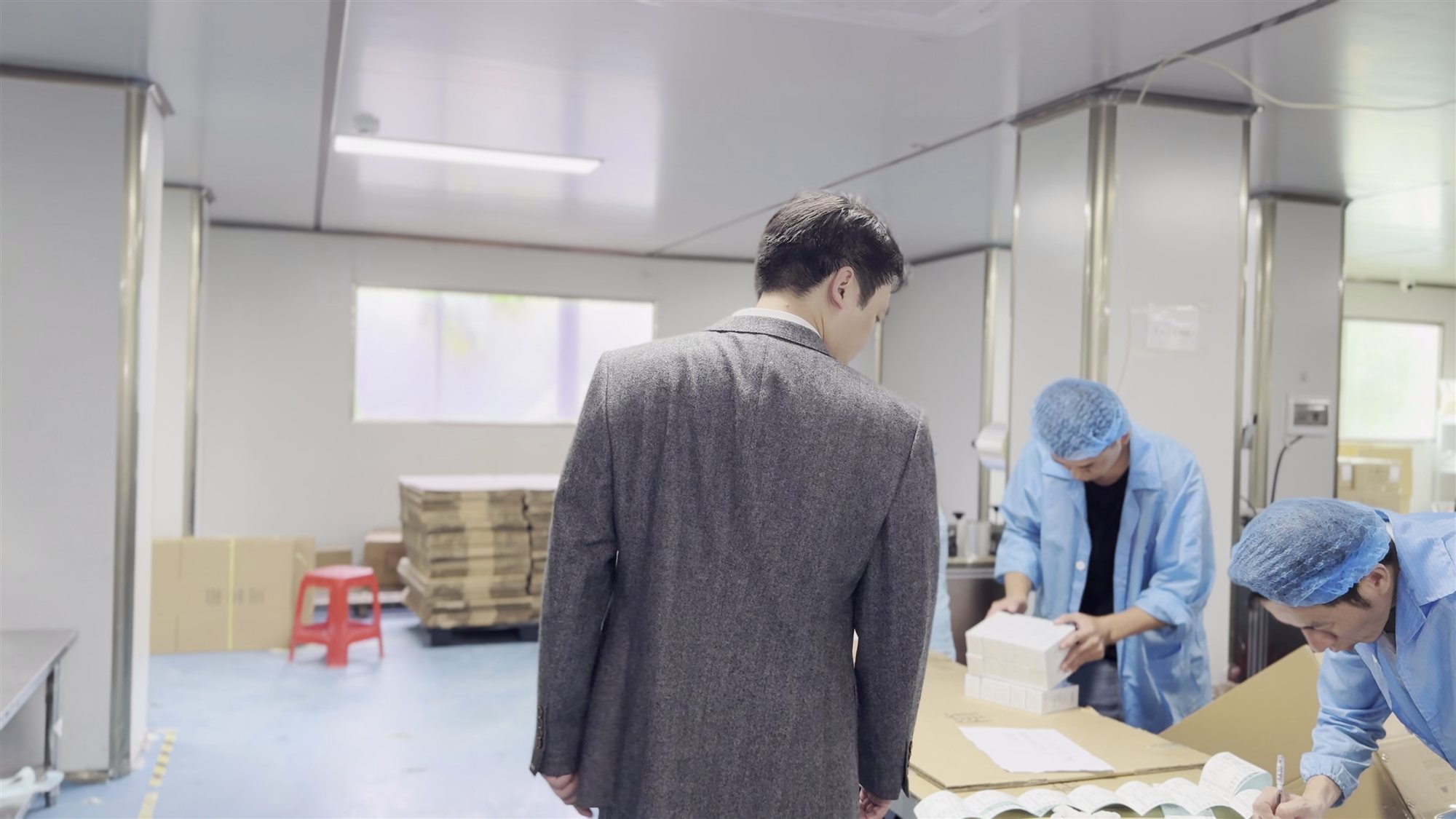 Tyler, founder of jogonglabs, walking through the production floor beside workers
