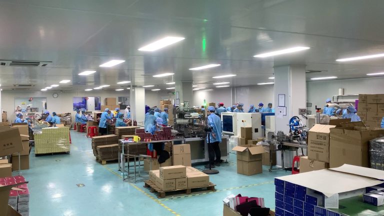 jogonglabs packaging hall during a production run, with staff at packing stations and cartons staged for shipping